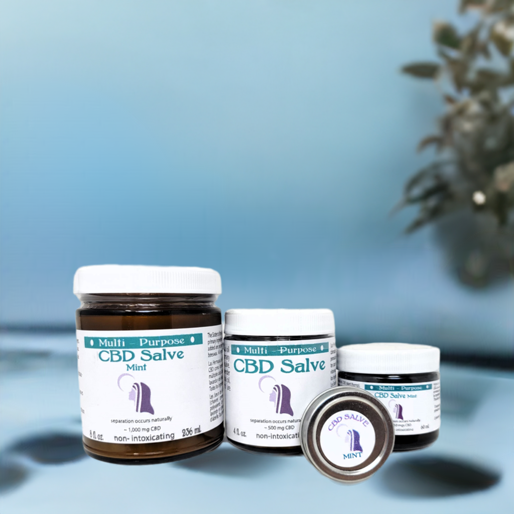 Four jars of CBD Topical Salve 8 oz. Lavender or Mint (~1,000 mg CBD) are displayed on a smooth surface with a blue background and a blurred plant to the right.