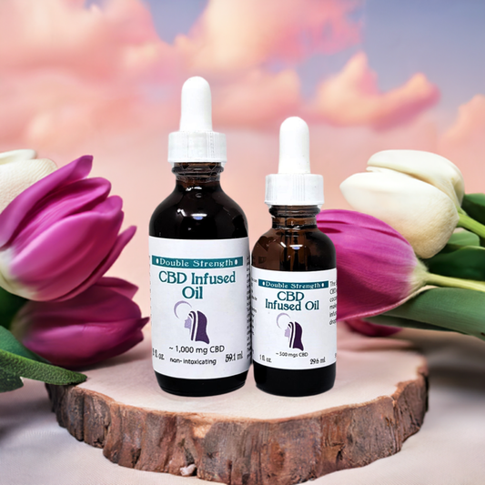 12 x CBD Infused Oil Double Strength bottles with droppers displayed on wooden surface with tulips background
